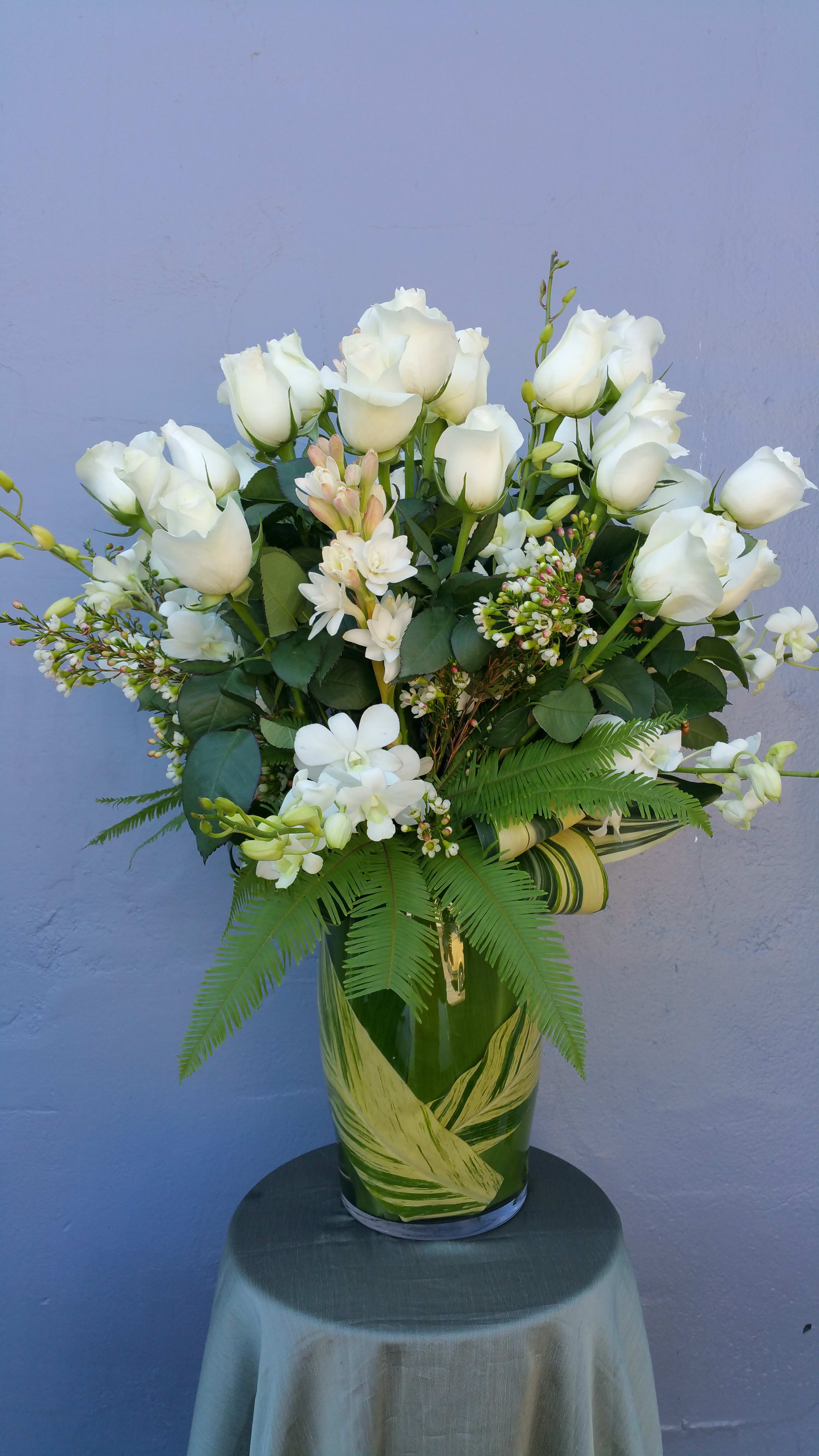 Proud  - Three dozen white roses, white wax, with tropical leaves and Dendros orchids