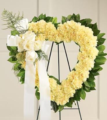 Our Hearts Speak to You Standing Heart -  This open heart design speaks volumes of loving memories. A heart of pale yellow carnations edged with lemon leaves tenderly holds five ivory roses trimmed with ivory ribbon.    Item # S8-4219 