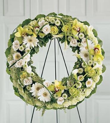 Wreath of Remembrance -  The Wreath of Remembrance is an abundant and elegant expression of your sympathies. Exotic green cymbidium orchids, white spray roses, white Gerbera daisies, white button poms and white mini calla lilies are arranged against a restful backdrop of pistachio carnations.    Item # S18-4050 