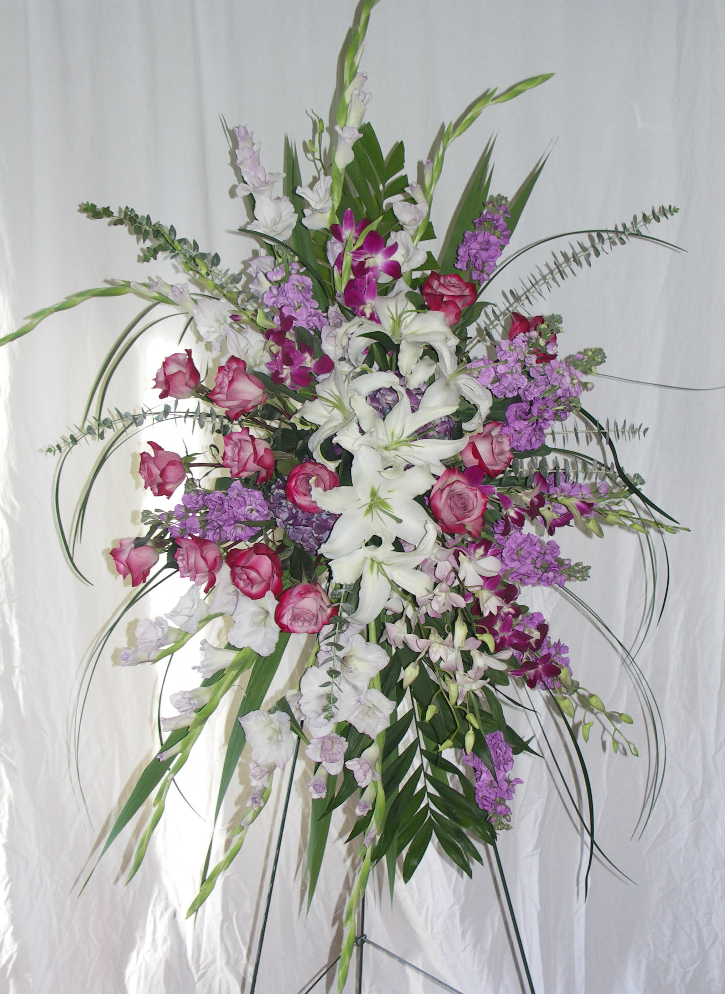 Passion Remembered - Sympathy Spray on an easle  wth lilies, roses, orchids and stock