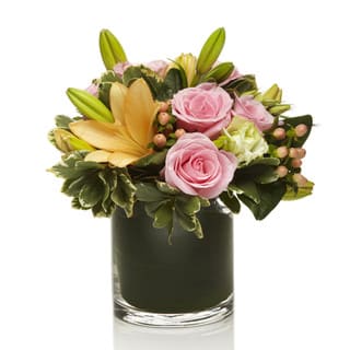 Sherbet by Sophisticated Blooms - A happy arrangement using soft pink roses, orange lilies and peach berries with a touch of greens. Arranged neatly in a chic glass vase.  • Orange Lilies • Pink Roses • Berries • Glass Cube or Cylinder Vase • Personalized Gift Message • The premier luxury floral gifting experience