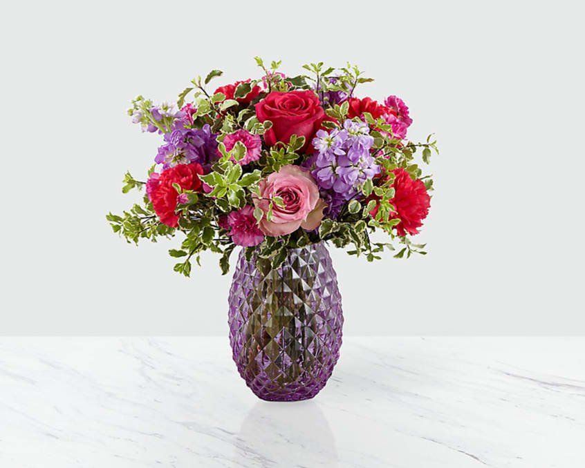 Perfect Day by Sophisticated Blooms - This bouquet is a charming way to celebrate any of life's most treasured moments, great and small. Blossoming with unmatched color and texture, this fresh flower arrangement brings together pink roses, hot pink roses, purple stock, hot pink carnations, violet mini carnations, and lush greens to create a gorgeous presentation. Arriving arranged in a purple glass vase with diamond pattern throughout to add even further texture and interest and give it an appealing vintage vibe, this spring flower bouquet is ready to help you send your warmest birthday, anniversary, or thank you wishes.