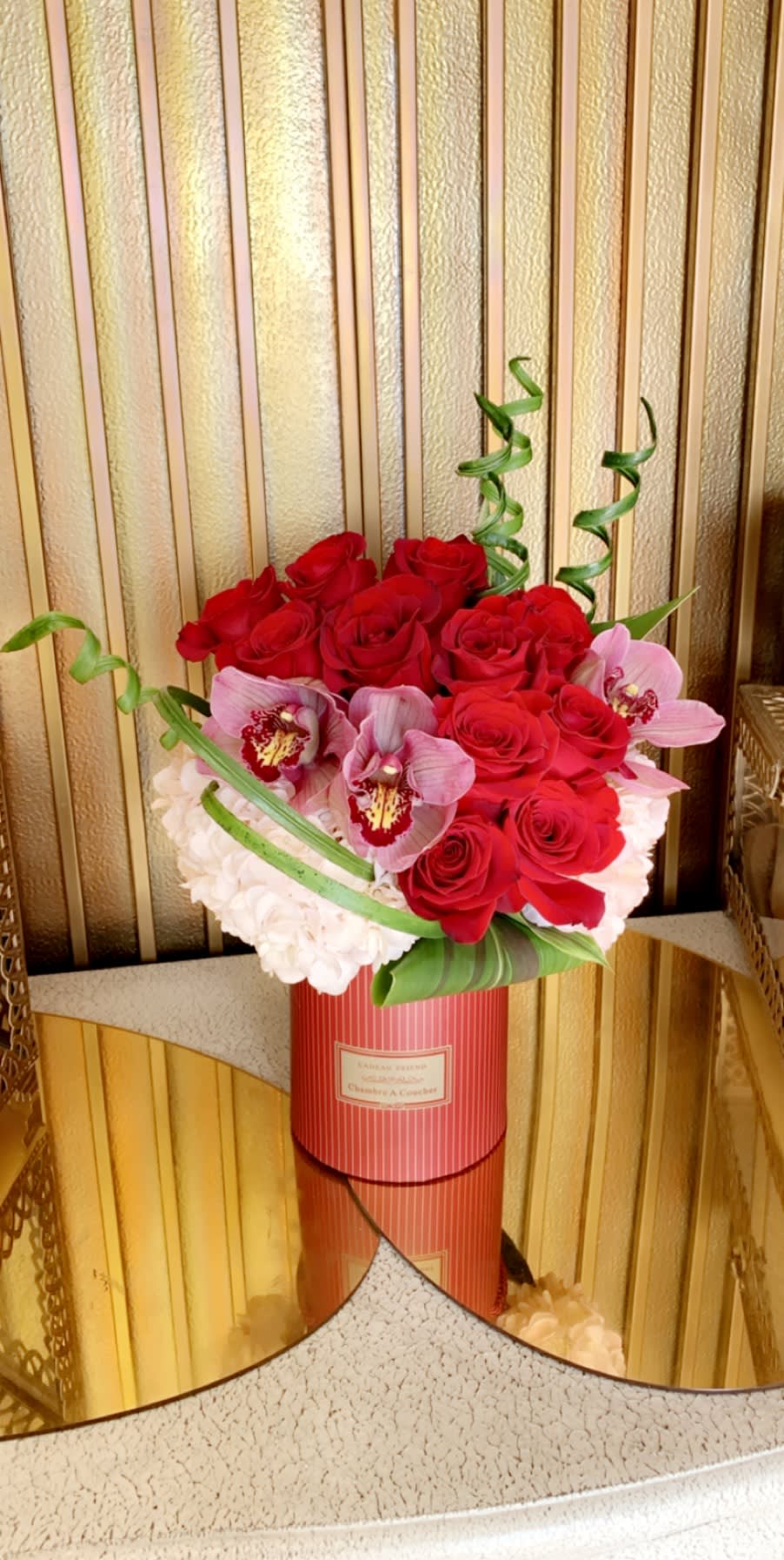 Button Red  - Designer Arrangement of roses, hydrangeas, orchids and decorative accessories in a beautiful red cylinder box