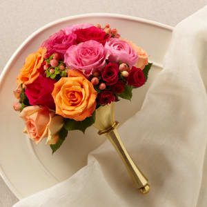 The FTD Bright Promise Bouquet The FTD Bright Promise Bouquet - The FTD® Bright Promise™ Bouquet is a combination of captivating color and stunning bridal elegance to create the perfect wedding day look. Orange peach pink and fuchsia roses are arranged amongst fuchsia spray roses pink ranunculus and peach hypericum berries all brought together in a gold metallic bouquet holder to create a bouquet of charm and grace.