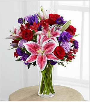 The Stunning Beauty™ Bouquet by FTD® - The Stunning Beauty™ Bouquet by FTD® is an absolutely lovely way to send your love and affection across the miles. Fragrant Stargazer lilies stretch their star-like petals across a bed of rich red roses, lavender carnations, red Peruvian lilies, purple double lisianthus, purple matsumoto asters and lush greens. Presented in a classic clear glass vase, this elegant bouquet is an incredible way to convey your sweetest sentiments.  BETTER bouquet is approximately 19&quot;H x 16&quot;W.  Lilies may arrive in various stages of development. The lily blooms will continue to open, extending arrangement life - and your recipient's enjoyment.. Your purchase includes a complimentary personalized gift message.