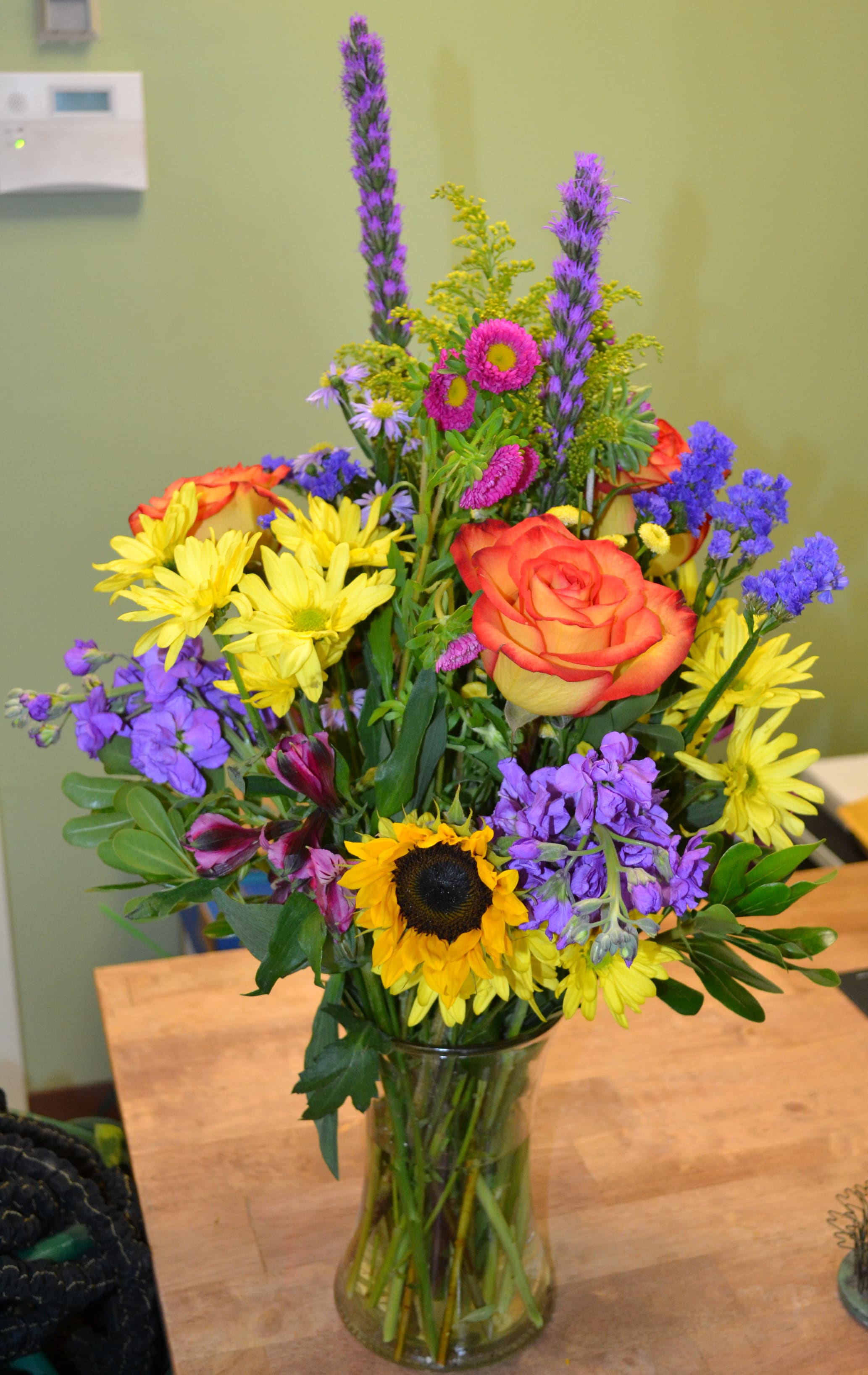 Vibrant Spring - Roses, Sunflowers, Stock, Liatris, Yellow Daisies and more in this perfect springtime arrangement.
