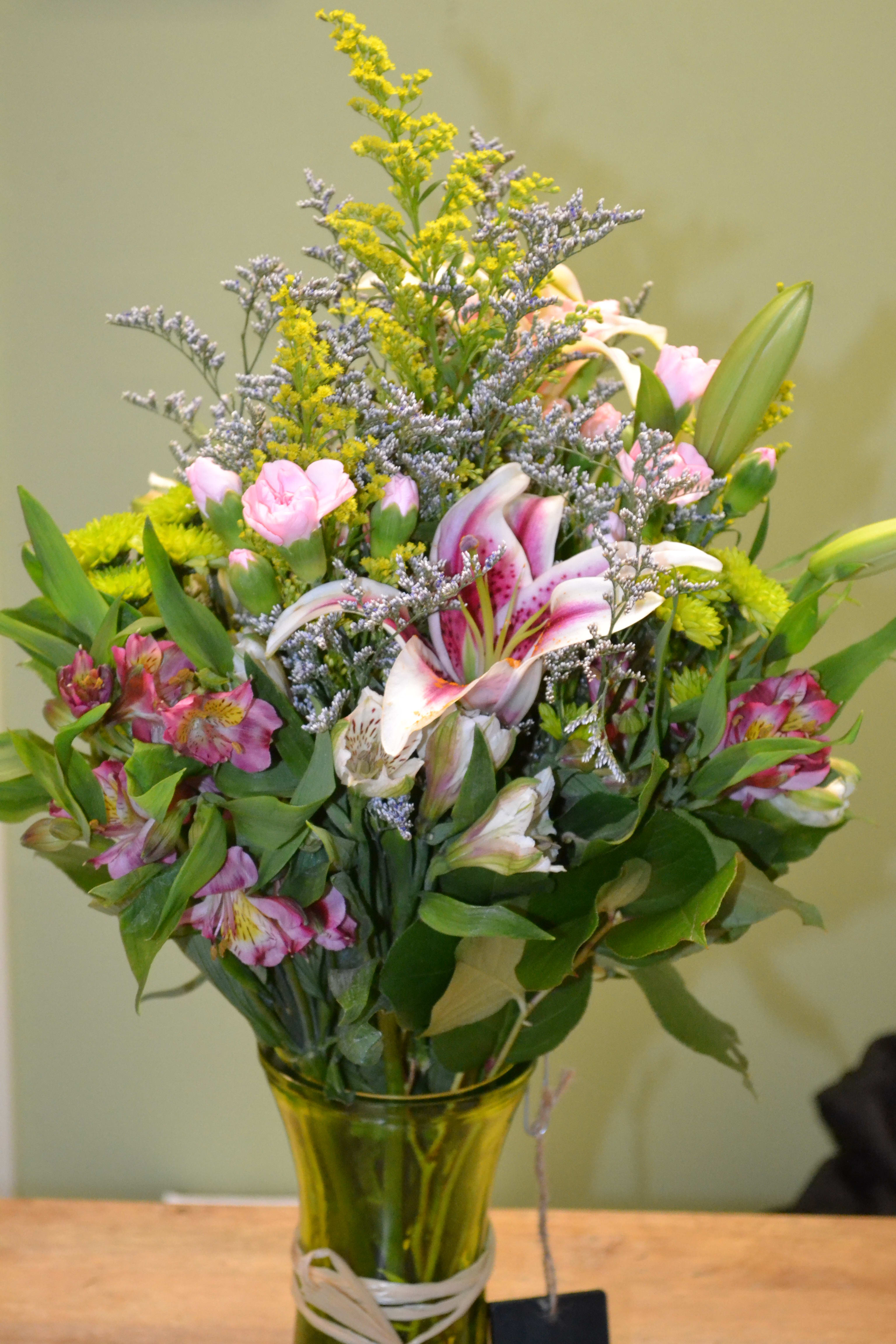 Perfect Sunshine - Add the perfect sunshine to their day. A green vase with solidago, green button poms, Alstro, stargazers, limonium, mini carnations and more is sure to add an instant touch of brightness!