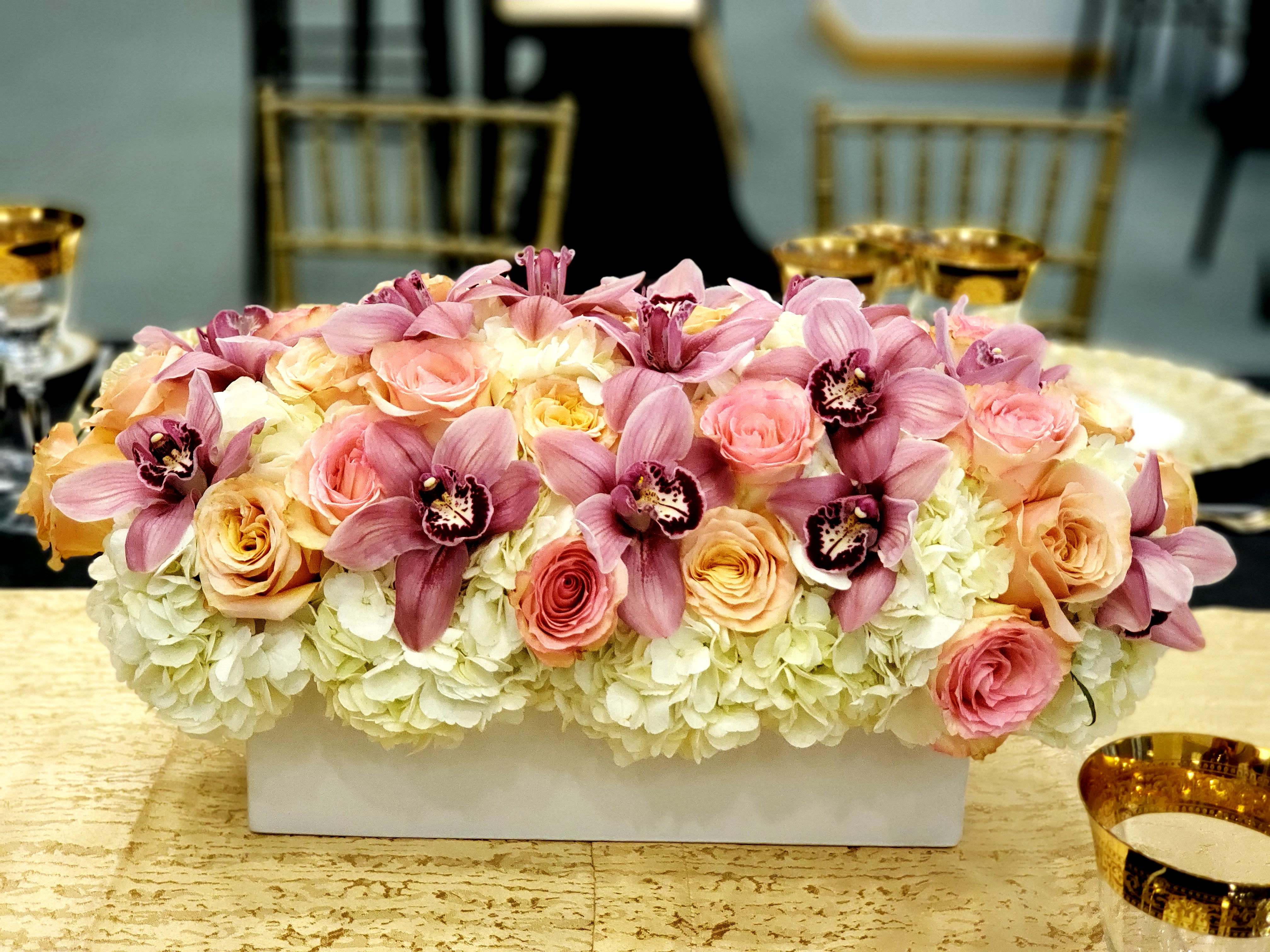 Grande Dame - Hydrangeas, cymbidium orchids,  blush &amp; peach roses in a white long rectangle container. 
