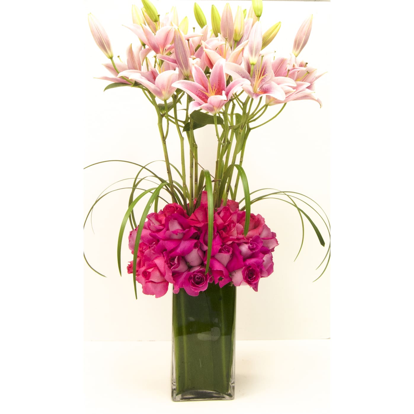 Pink Lilies and Hot Pink Roses - Tall arrangement of Pink Oriental Lilies and hot Pink Roses in a Tall Leafed Vase. Approx. 30&quot; Tall X 12&quot; Wide Available in many other colors