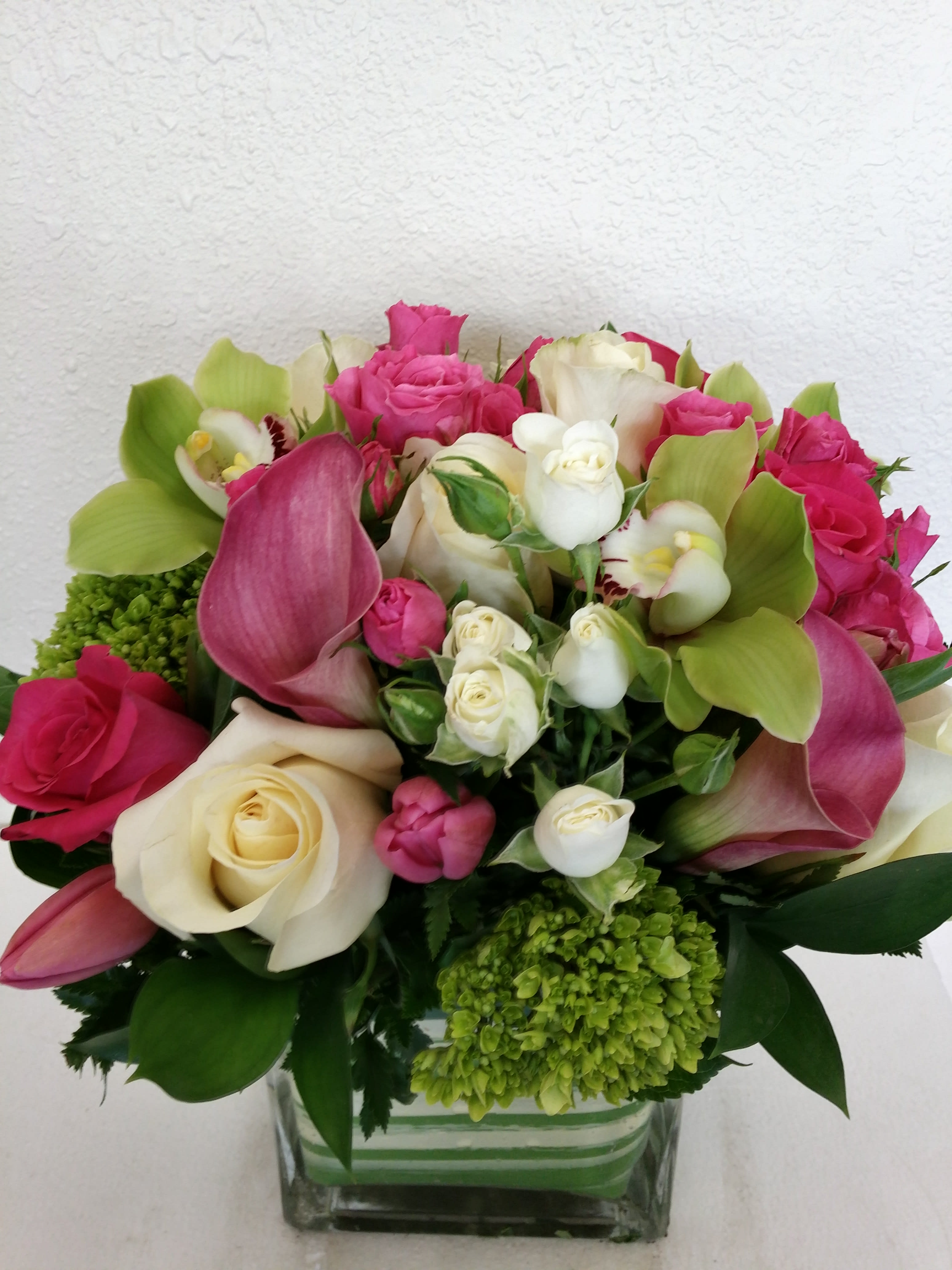 Pretty in Pink! Pretty in Pink! - contemporary styling, pink and white roses, hydragea, calla lilies, orchids and baby spray roses, leaf lined vase with a striped green and white wrap