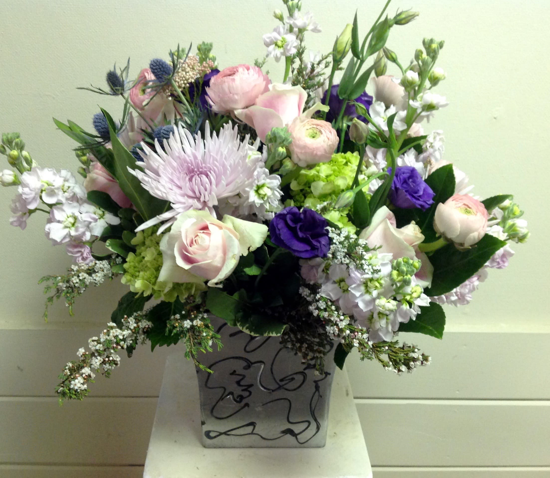 Moms the Word - spider mums, ranunculus, roses, lisianthus, stock, green hydrangea, eringium in container with seasonal fillers.