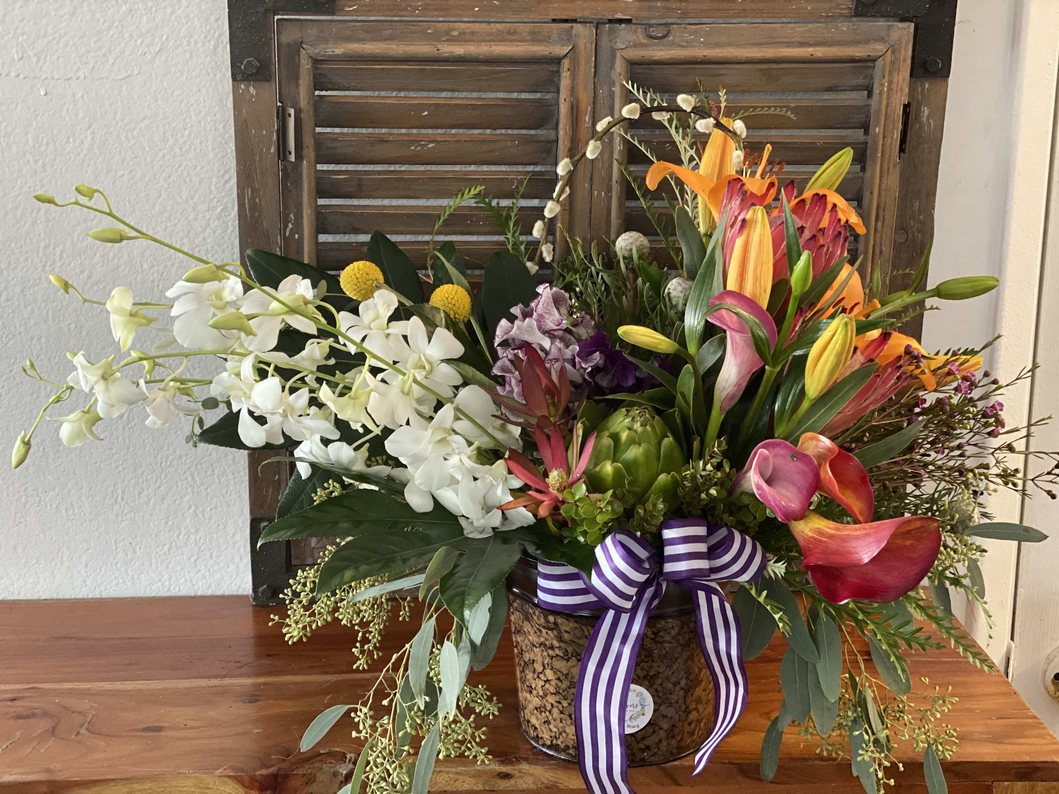 Sentiment's Explosion  - Tropical bouquet  has a warm, welcoming look that will win over your special recipient with each sunlit bloom. Orange Callas  and Peruvian Lilies are set to brighten their day, arranged amongst bright white traditional dendrobiums Orchids 