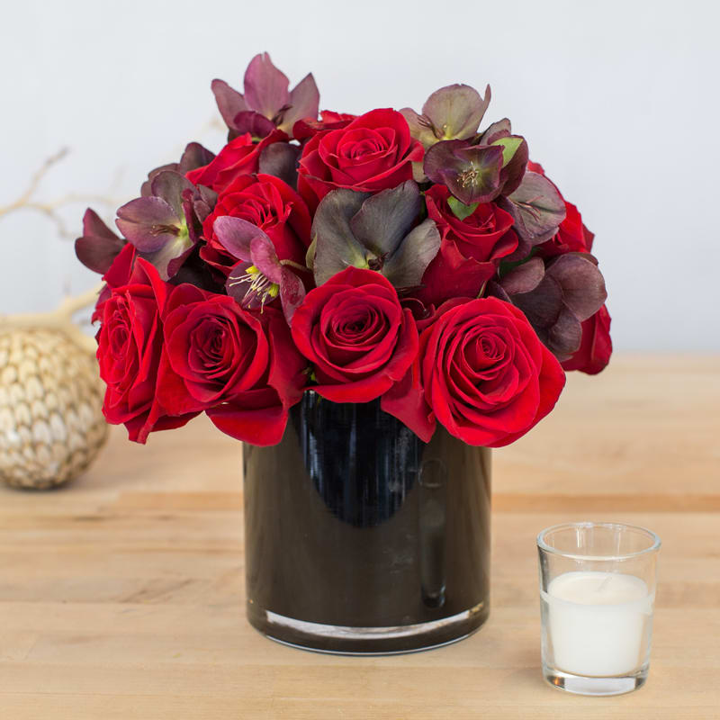 Red and Purple Mixed Floral Arrangement (Black) - This fresh floral arrangement of dark roses and dark purple is perfect for any occasion no matter how big or small. Containers come in clear, white, black, and leaf line. 