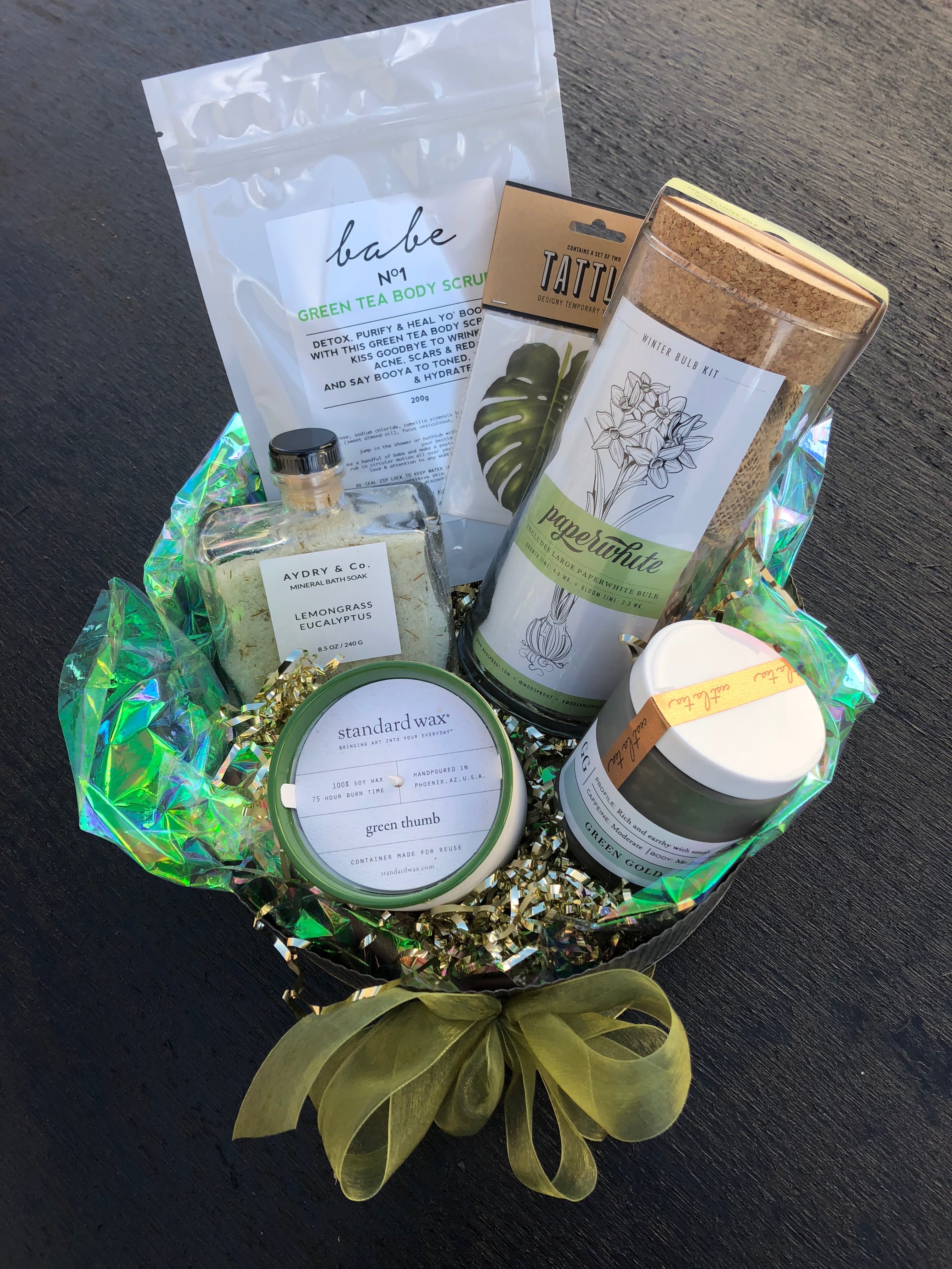 &quot;Green Thumb&quot; Gift Basket - A fresh and rejuvenating gift basket, perfect for that special someone who likes to go green!  This basket includes: Green Tea body scrub by Babe, Paperwhite Winter bulb kit by Modern Sprout, Lemongrass and Eucalyptus bath soak by Aydry &amp; Co., Green Thumb soy candle by Standard Wax, Green Gold loose leaf tea by Teaspressa, and a monstera leaf temporary tattoo. 