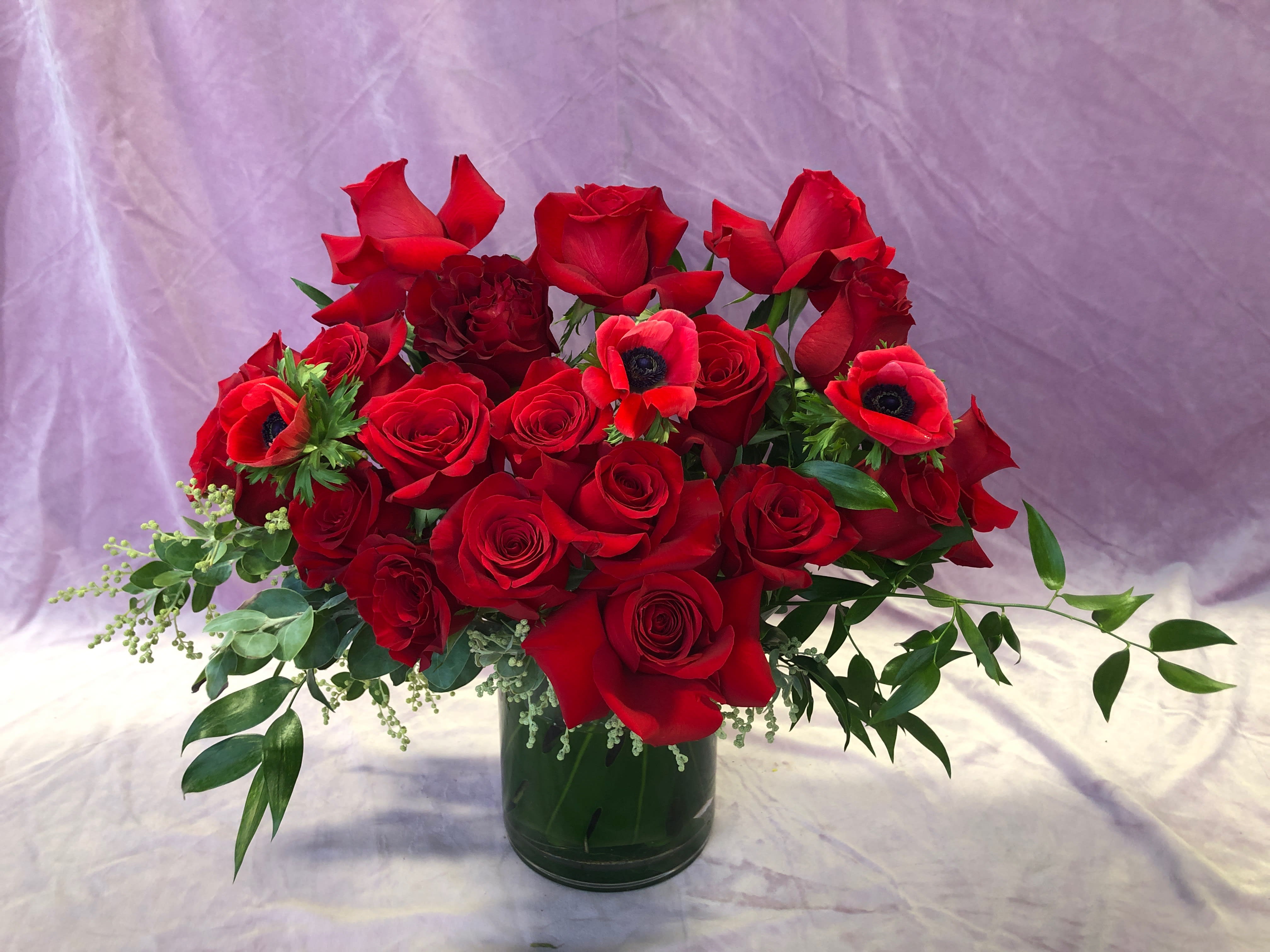 Heartthrob - This garden style, red floral arrangement is sure to pull at any heart string. This arrangement may include red roses, red garden roses, red anemones, and other beautifully toned elements. Over 20 roses and accent flowers make up this gorgeous handmade arrangement. 