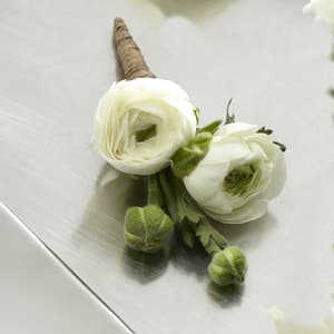 The FTD® White Ranunculus Boutonniere The FTD® White Ranunculus Boutonniere - The FTD® White Ranunculus Boutonniere gives a modern twist to the look of the groom and groomsmen on the wedding day. A single stem of white ranunculus boasting 2 to 3 blooms and additional buds has a textured appeal that adds interest and soft sophistication to any wedding style.