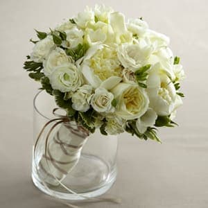 The FTD® Romance Eternal™ Bouquet -  The FTD® Romance Eternal™ Bouquet has a dream-like appeal that will be the perfect accessory on your wedding day. Gorgeous white ranunculus, roses, freesia, mini calla lilies, peonies, spray roses and hydrangea are brought together in this exquisite arrangement with lush greens and tied together with an ivory satin ribbon accented with a gold and ivory double sided stitch-edged satin ribbon to create a bouquet that speaks of the romance and heartfelt commitment made on this most remarkable day. 
