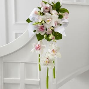 The FTD® Perfect Entrance™ Pew Arrangement -  The FTD® Perfect Entrance™ Pew Arrangement creates the ideal ambiance for your trip down the aisle. White and pink Cymbidium Orchids are brought together with Dendrobium Orchids and lush greens, gorgeously accented with white taffeta and satin ribbons, to create an exceptional display of bridal elegance. 