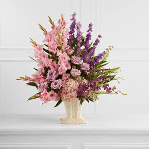 The FTD® Flowing Garden™ Arrangement  -  The FTD® Flowing Garden™ Arrangement bursts with a bounty of blooms to create a stunning tribute of the deceased at their final farewell service. Lavender roses, pink gladiolus, purple dendrobium orchids, purple larkspur and pink hydrangea are accented with an assortment of lush, vibrant greens and perfectly arranged in a papier mache urn to create a presentation of grand beauty that symbolizes the life of the departed. 
