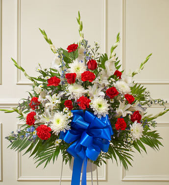 Red White And Blue Sympathy Standing Basket - Product ID: 91270   Convey your deepest condolences for a beloved veteran with this touching tribute. Our florists arrange beautiful red, white and blue flowers such as roses, hybrid lilies, cremones, delphiniums, carnations and more Traditionally sent by family, friends or business associates Sent directly to the funeral home Due to the sensitivity of the occasion, our florists use only the freshest flowers available, so colors and varieties may vary Arrangement measures approximately 32&quot;H x 36&quot;L without stand