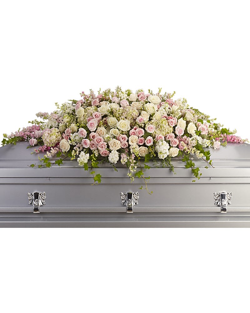 Always Adored Casket Spray - A beautiful spray of soft pink white and crÃ¨me blooms ease the burden of loss. Pink hydrangea larkspur and roses mingle with white roses stock and waxflower. Ivy fern and fragrant eucalyptus act as green accents in this spray that rests atop the casket.
