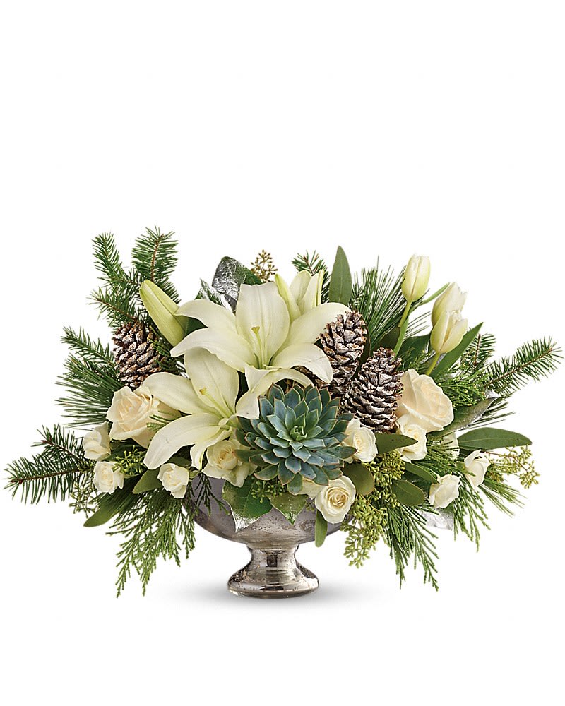 Teleflora's Winter Wilds Centerpiece - Fresh winter greens and snow-white blooms are paired to perfection in this unique centerpiece presented in a mercury glass bowl. This beautiful arrangement of crÃ¨me roses white spray roses white tulips and white asiatic lilies is accented with seeded eucalyptus lemon leaf flat cedar douglas fir white pine and a large green echeveria succulent. Delivered in a mercury glass bowl.