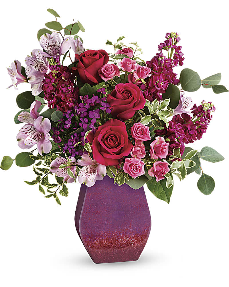 Teleflora&#039;s Rare Jewels Bouquet - Make mom feel like the rare treasure she is with this magnificent bouquet of pink roses and lavender blooms! Its jewel tones are perfectly paired with a hand-glazed ceramic vase that sparkles with a glossy gradient finish. Hot pink roses, pink spray roses, lavender alstroemeria, pink sweet william, and fuchsia stock are accented with silver dollar eucalyptus and pitta negra. Delivered in a Regal Blossoms vase.