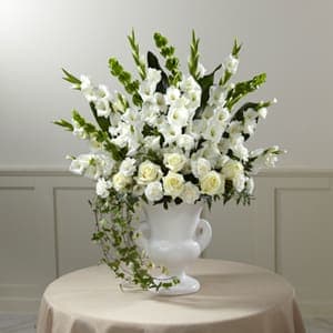 The FTD® Fond Reflections Arrangement The FTD® Fond Reflections Arrangement - An expression of sympathy that’s tasteful, dignified and with a beautiful sensibility that conveys your feelings with warmth and sincerity. This generously-scaled arrangement makes a superb choice with hand-selected white gladioli, carnations, roses and Bells of Ireland complemented with lush greenery by an FTD local artisan florist and arranged in a classic white ceramic urn. Its comforting presence and impressive scale makes a fitting tribute for a wake, the funeral service, or to add a note of serene consolation to a graveside service.