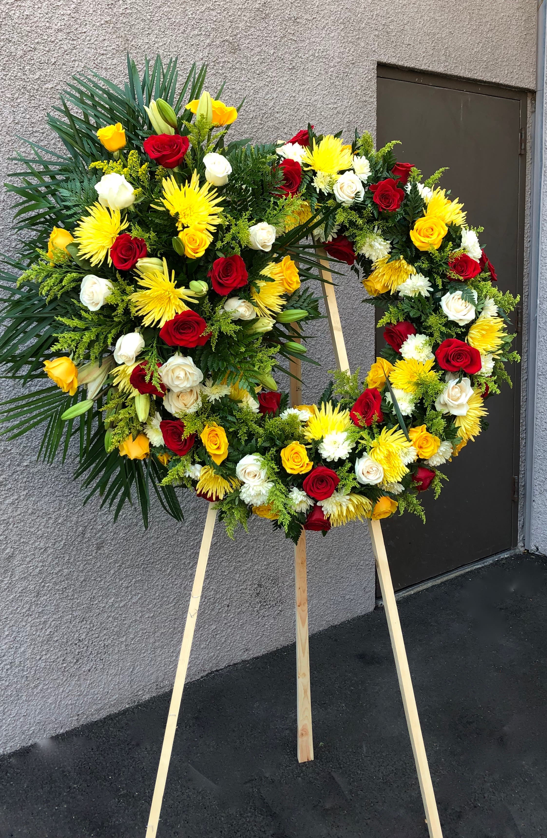 Vibrant Wreath Vibrant Wreath - Large wreath with one bouquet on the left side. With roses, lilies, solidago, spider flower, leather,