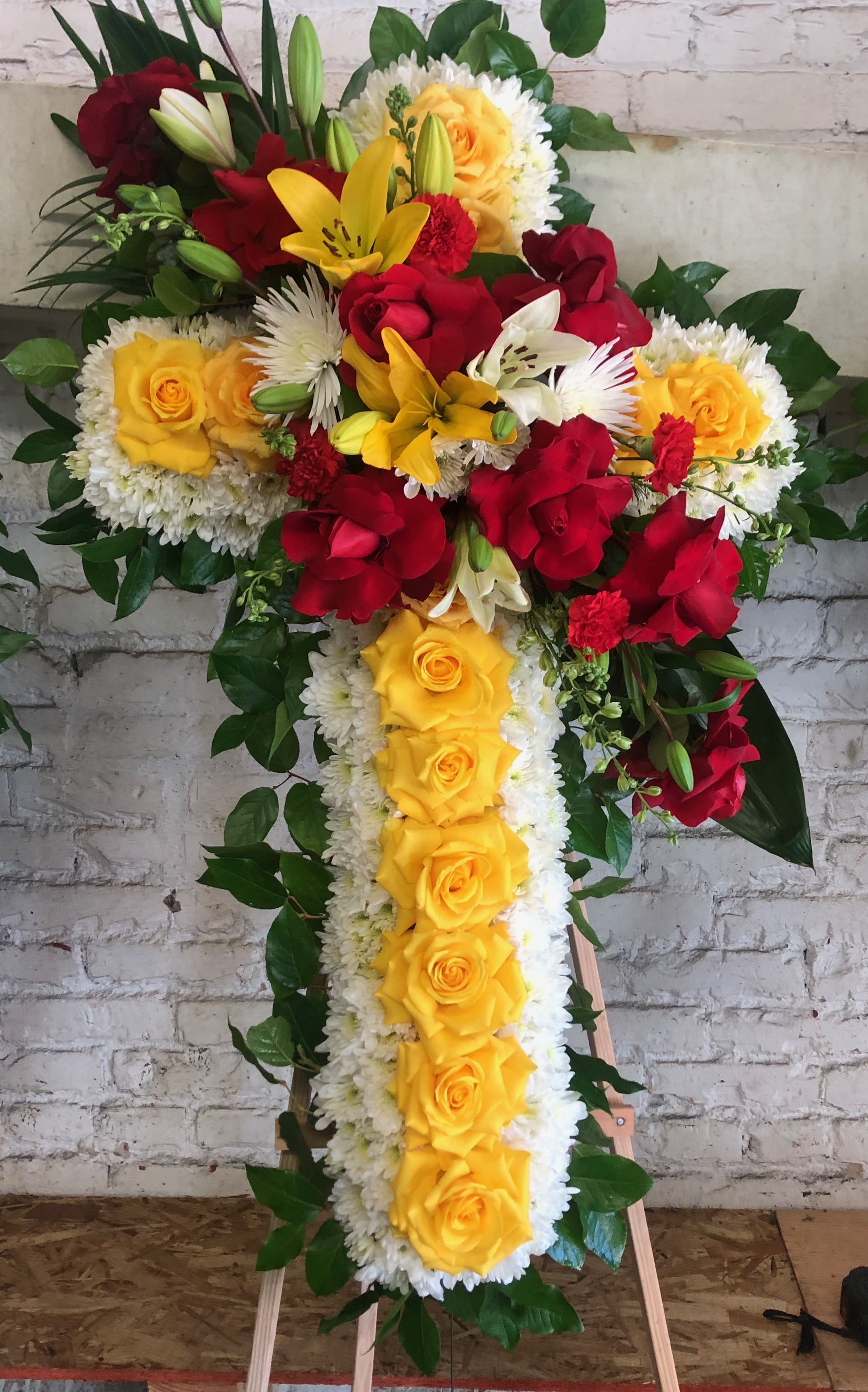 Colorful Cross Colorful Cross - Medium cross with roses, pom pom, larkspur, tropical leafs, spider flowers, and lilies We can make this arrangement in any color. Feel free to reach out to us at any time and we will gladly help you.