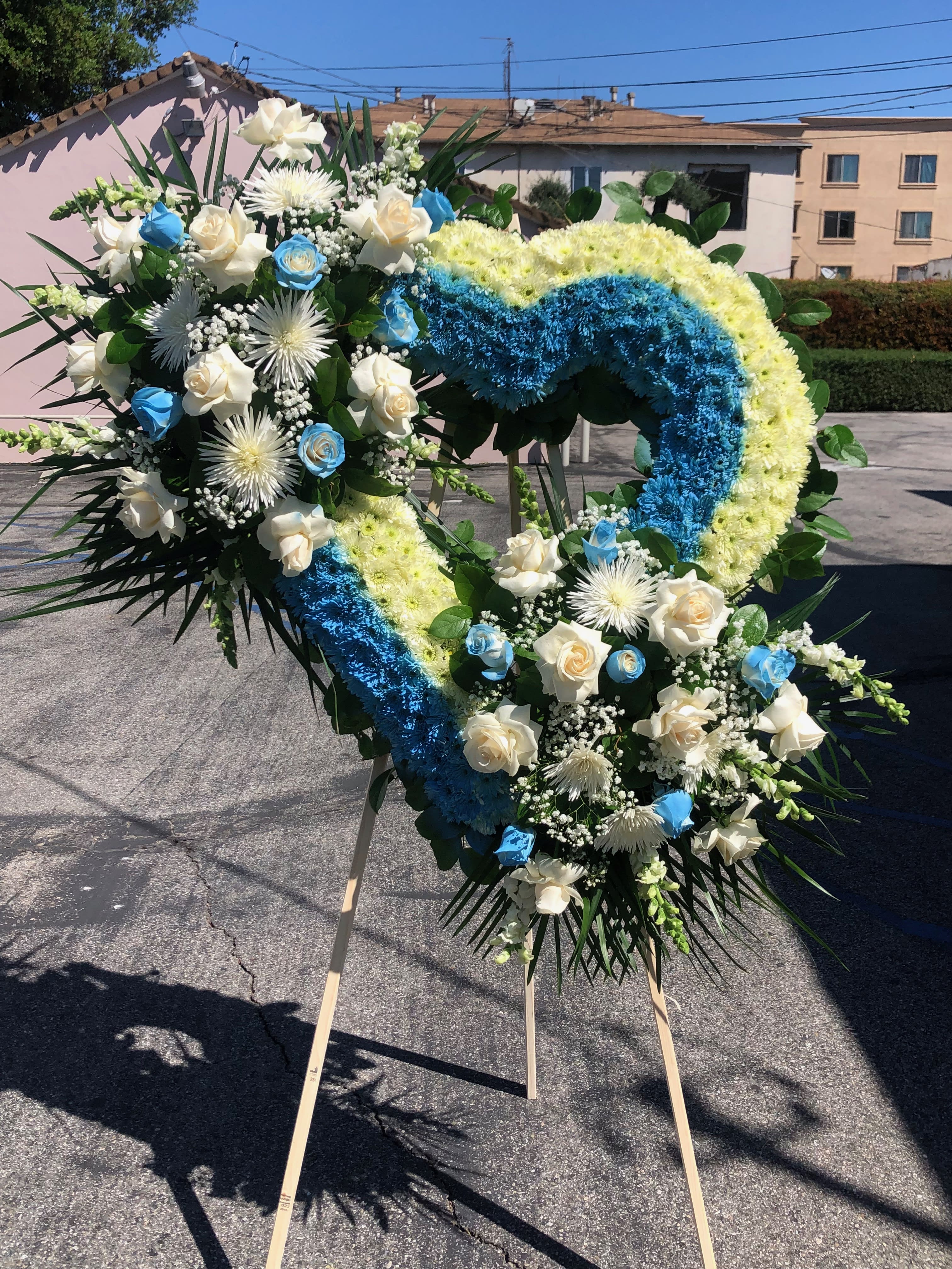 Light Blue Heart Light Blue Heart - Large Heart with 2 bouquets . that contains pom pom, open roses closed roses, spider flower, babies breath, snapdragon, and tropical leafs. We can make this arrangement in any color. Feel free to reach out to us at any time and we will gladly help you. Red oriental wreath Red, White, Green Everything Blossoms Team of talented florist