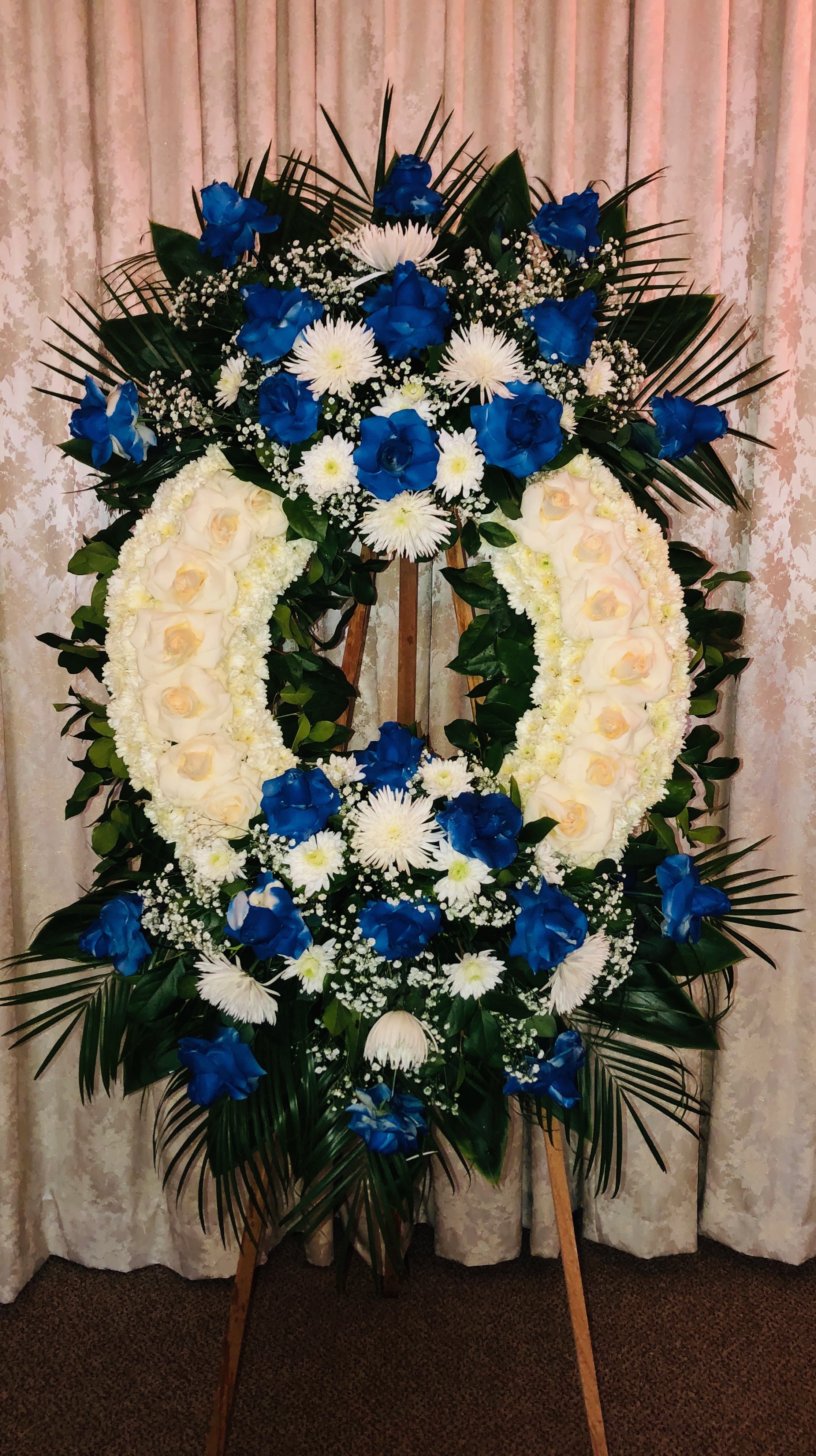 Blue Wreath Blue Wreath - Large Wreath with 2 bouquets, roses, pom pom, tropical leafs babies breath spider flowers. We can make this arrangement in any color. Feel free to reach out to us at any time and we will gladly help you.