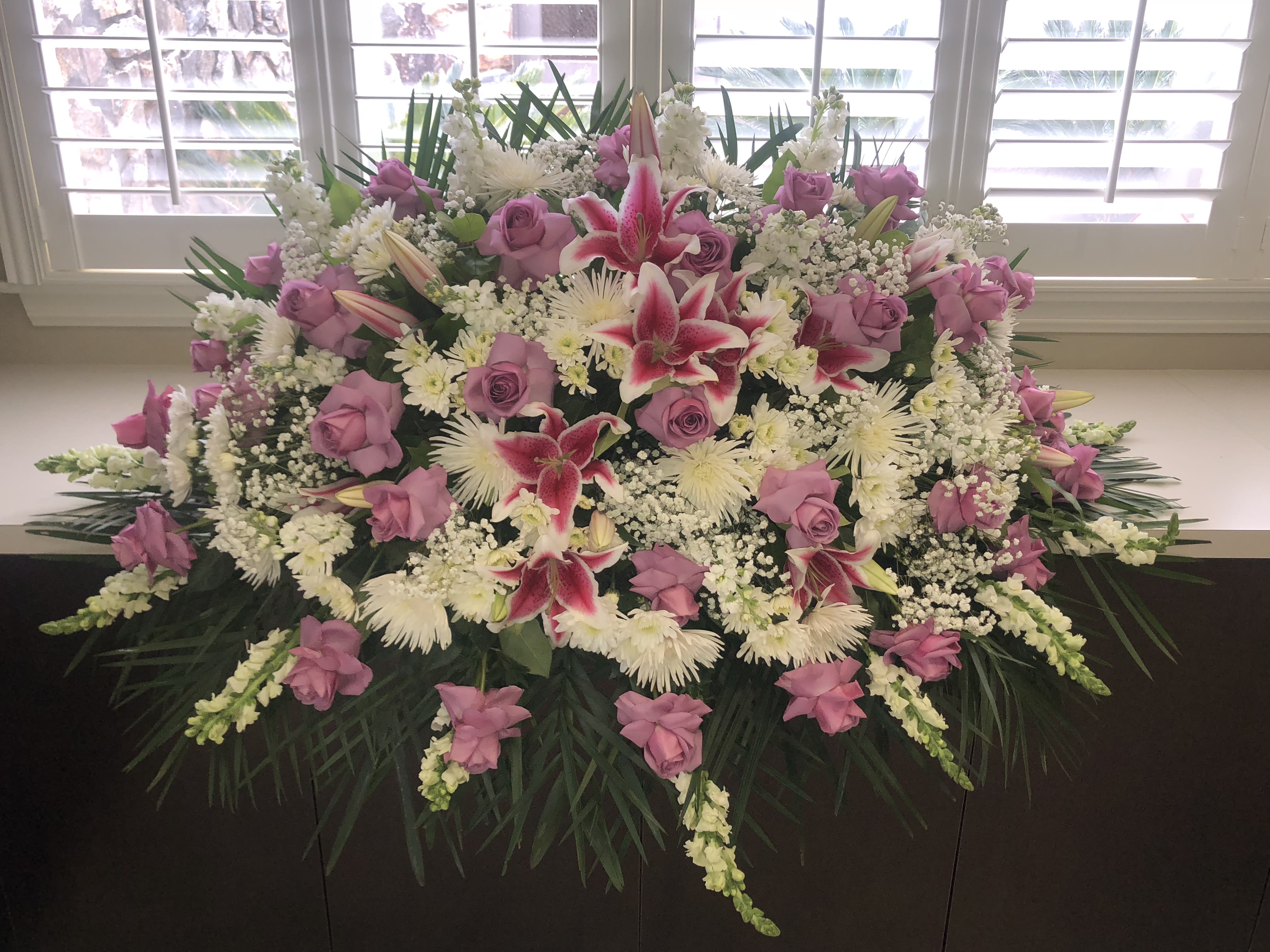 Lavender casket spray Lavender casket spray - Half a caste spray with topical leas pom pom, babies breath, opened roses, spider flowers, snapdragon and stargazers. We can make this arrangement in any color. Feel free to reach out to us at any time and we will gladly help you.