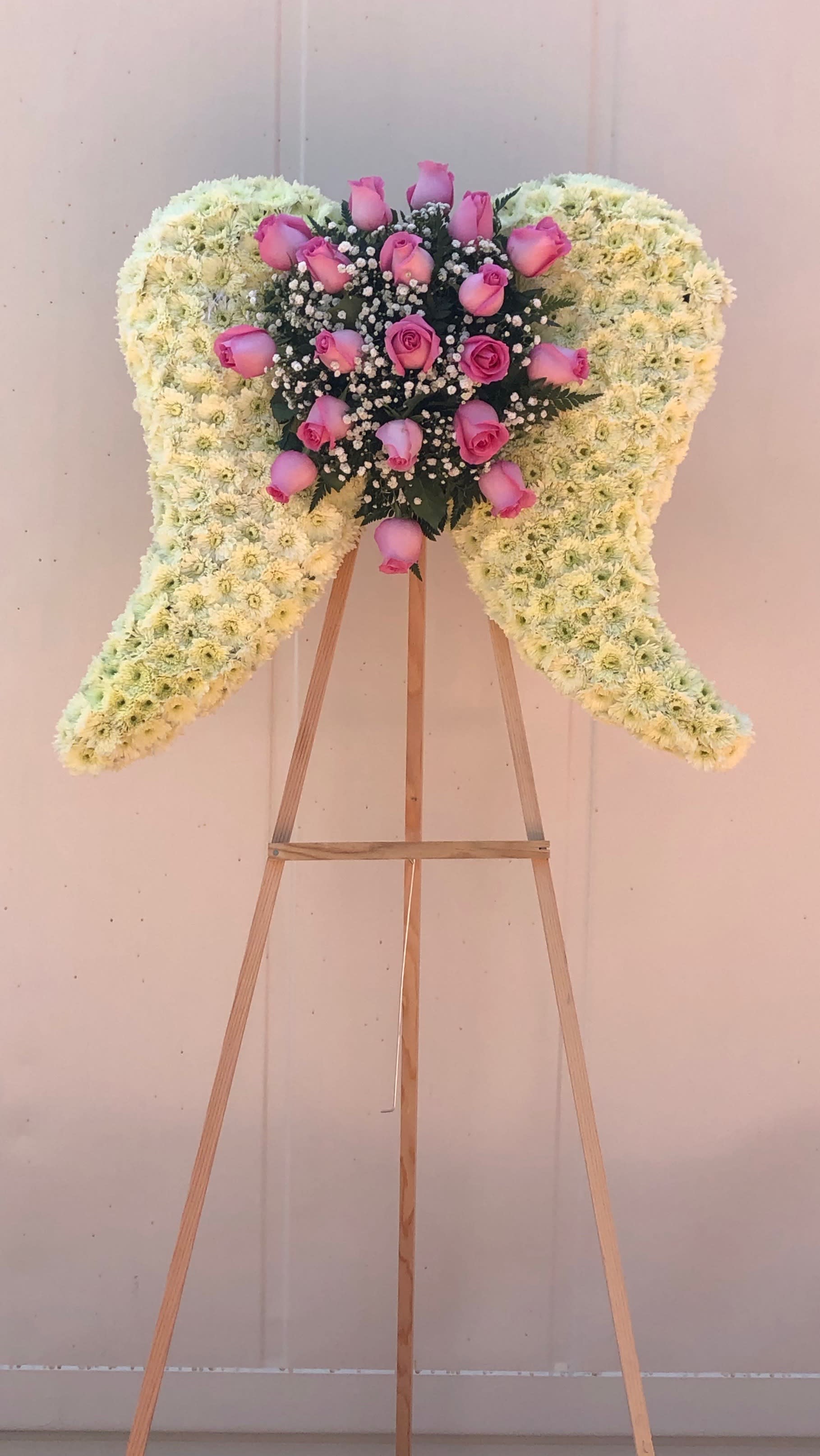 Heavenly Wings. Heavenly Wings. - Large angel wings with roses, pom pom , leather and babies breath Note: the arrangement can be made in other colors upon request.