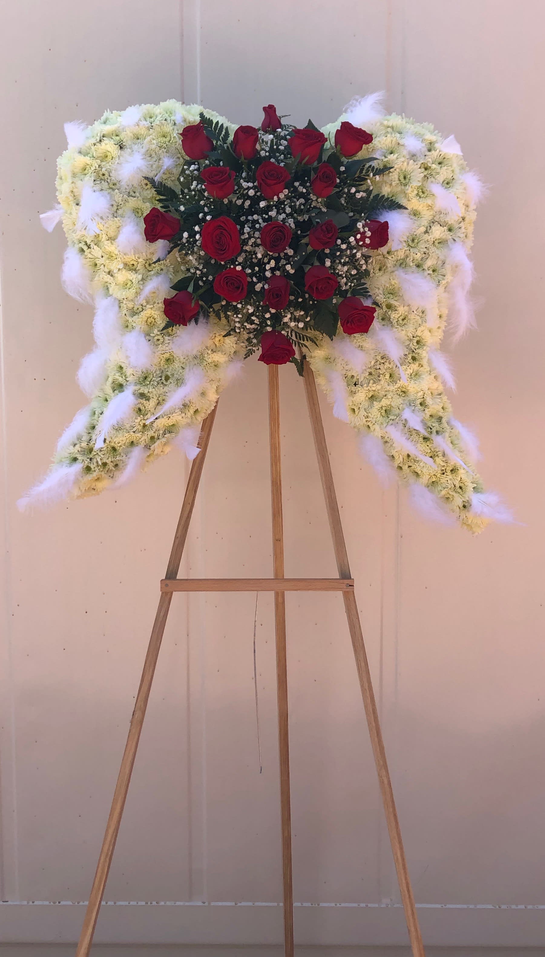 Flying high Flying high - Medium angel wings with roses, pom pom , leather and babies breath, with feathers.\ Note: the arrangement can be made in other colors upon request.