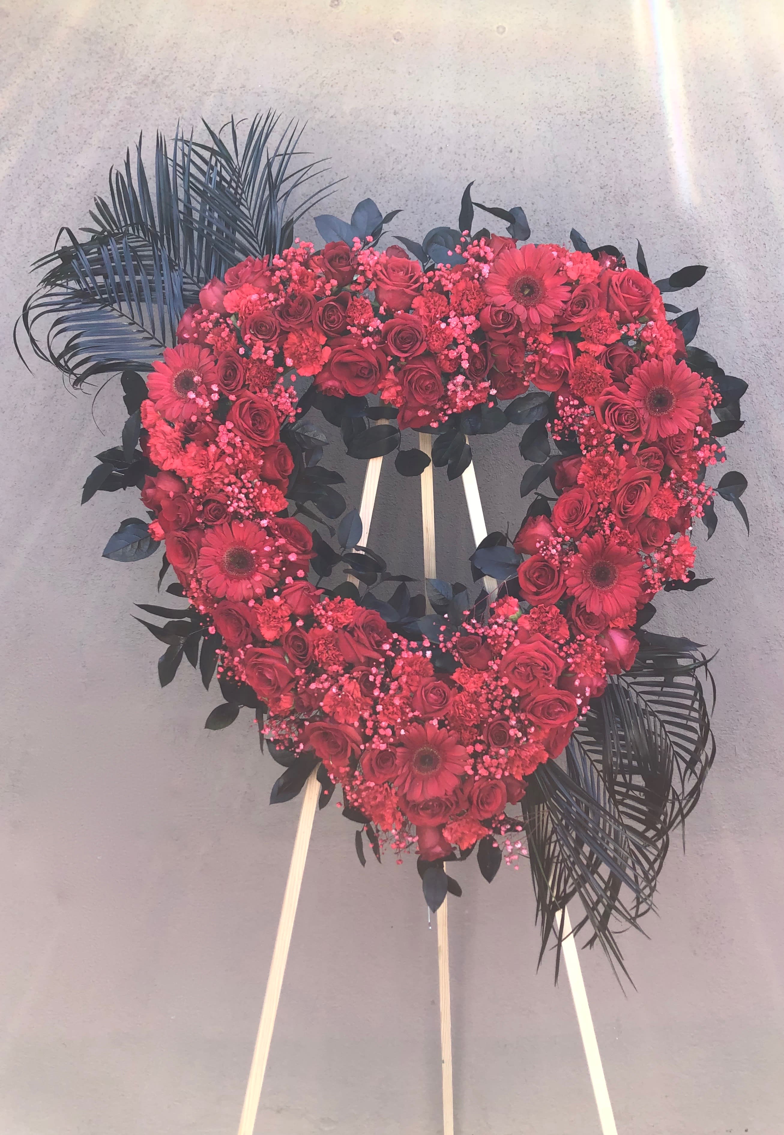 We Love You We Love You - Large Heart withs rose ,Gerber daisies, carnations, babies breath and tropical leafs. Note: the arrangement can be made in other colors upon request.
