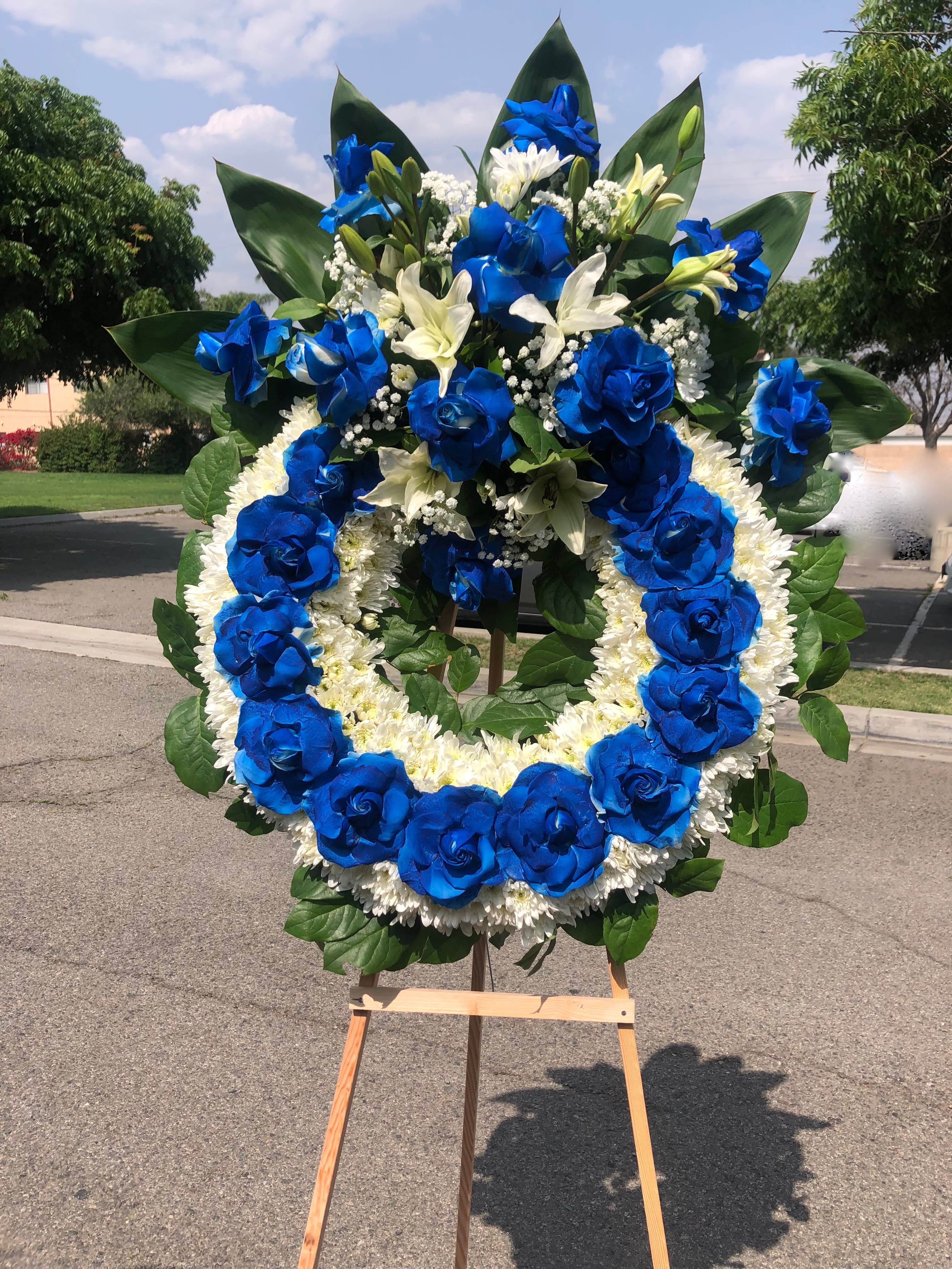 Navy blue wreath Navy blue wreath - Medium wreath with roses , pom pom, lilies, babies breath and tropical leafs.Note: the arrangement can be made in other colors upon request. Note: the arrangement can be made in other colors upon request.