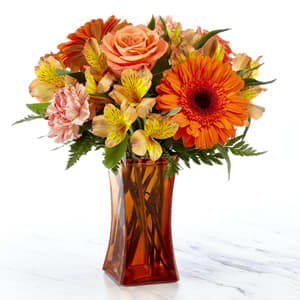 The FTD® Orange Essence Bouquet- VASE INCLUDED - The FTD® Orange Essence™ Bouquet is a bright and sunny way to celebrate any of life's special moments! Bringing energy and beauty straight to your special recipient's door, this fresh flower arrangement unites orange roses, gerbera daisies, carnations and Peruvian Lilies along with lush greens, to create an incredible gift of flowers. Presented in a modern orange glass vase to give it a polished and finished look, the flower bouquet is a wonderful way to express your happy birthday, thinking of you, or congratulations wishes. GOOD bouquet is approximately 13&quot;H x 11&quot;W. BETTER bouquet is approximately 14&quot;H x 12&quot;W. BEST bouquet is approximately 15&quot;H x 13&quot;W.