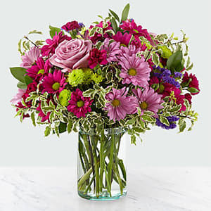 The FTD® Sweet Nothings Bouquet - Dazzle your customers with stunning violet and green hues set within a glass cylinder vase. A collection of roses, daisies and statice, our Sweet Nothings Bouquet sends sweet sentiment deep within each bloom. GOOD bouquet is approx. 14&#8243;H x 14&#8243;W. BETTER bouquet is approx. 15&#8243;H x 15&#8243;W. BEST bouquet is approx. 16&#8243;H x 17&#8243;W.