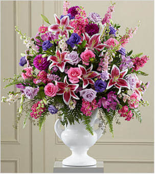 The FTD® Peaceful Tribute&amp;trade: Arrangement - Extravagant, beautiful and comforting, this generously scaled arrangement eloquently expresses your sympathy with an abundance of love and a profound manifestation of loss. Handcrafted by a local FTD artisan florist, it combines a colorful profusion of lavender and hot pink roses, pink statice, purple lisianthus and dahlias, Stargazer lilies and lavender alstroemeria ehanced with a rich and exotic variety of lush greenery in a classically-inspired white ceramic urn. It is an extraordinary choice that makes a big statement, sure to be noticed, greatly appreciated and and long-remembered for a wake or funeral service. Your purchase includes a complimentary personalized gift message.