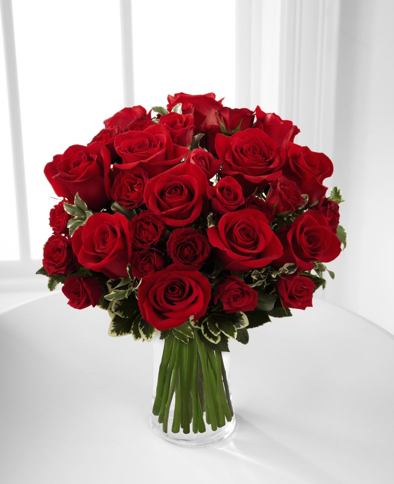 The FTD® Red Romance™ Rose Bouquet - Premium - The FTD® Red Romance™ Rose Bouquet will dazzle your special recipient with its expression of love and beauty this coming Valentine's Day. Rich red roses and spray roses are gorgeously arranged in a clear glass vase, accented with a lovely mix of greens, to create a bouquet bursting with romantic intentions.  