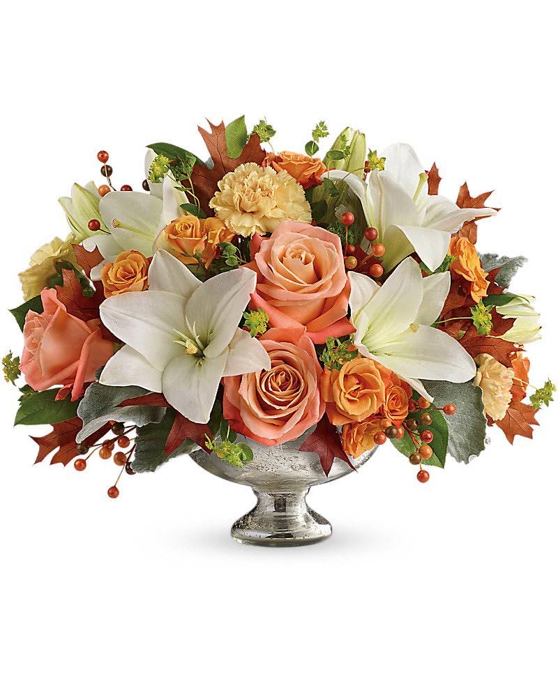Teleflora&#039;s Harvest Shimmer Centerpiece - Dress their fall table to impress by sending this shining bowl of the season&#039;s finest! Hand-delivered in a stunning mercury glass bowl, this artistic mix of white lilies and peach roses is sure to make their season a memorable one. This stunning centerpiece arrangement features peach and light orange roses, white asiatic lilies, peach carnations and orange berries and is finished with dusty miller, bupleurum and lemon leaf. Delivered in a Mercury Glass bowl.