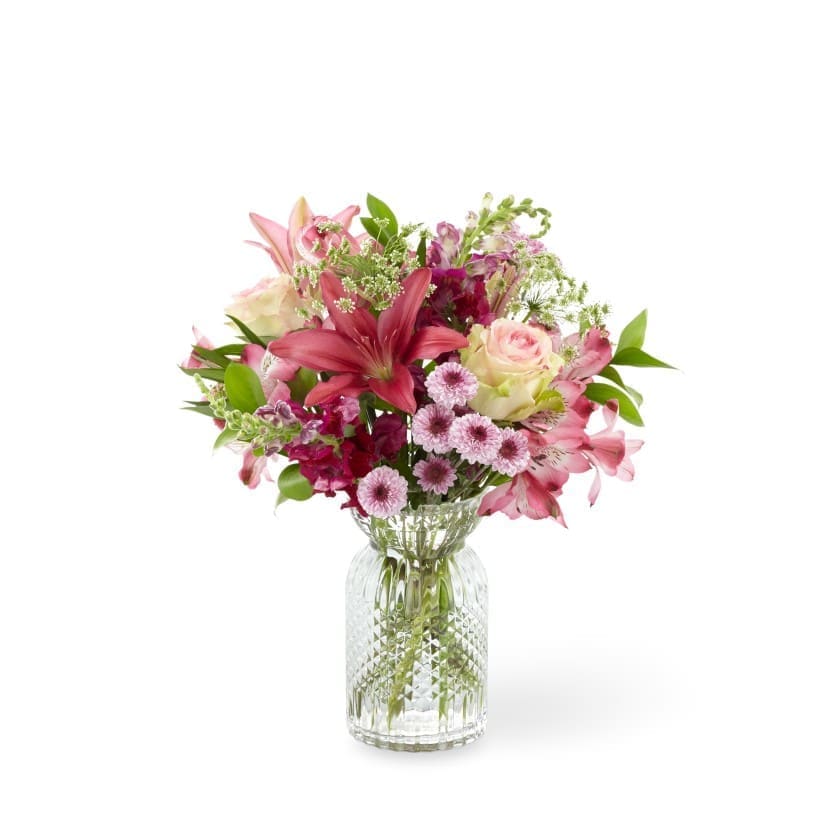 The FTD® Adoring You™ Bouquet - Whether it’s your mom, your grandmother, or any mother in your life, make sure they know how special they truly are. Our stunning Adoring You Bouquet is comprised of bi-color pink roses, dark pink Asiatic lilies, burgundy snapdragons, and Queen Anne’s Lace. These elegant blooms are highlighted by lavender button pompon and pink alstroemeria within a textural clear glass vase. This gorgeous arrangement comes together to deliver a message of heartfelt love for Mother’s Day, or any occasion.