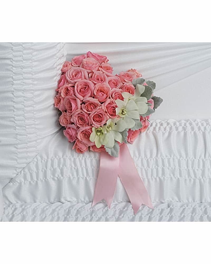 Divine Serenity Casket Insert - A heartfelt tribute to your love, this sweet pink rose heart is adorned with delicate white orchids for an uplifting casket arrangement. White dendrobium orchids and pink spray roses are accented with dusty miller and light pink ribbon.