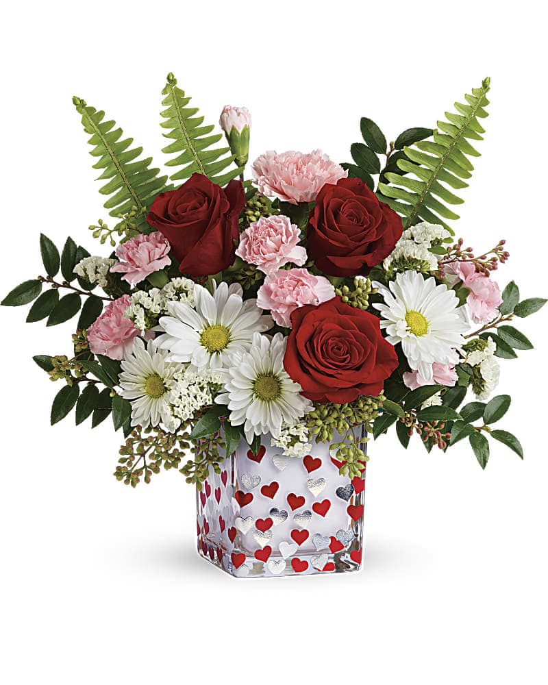 Teleflora's Pop Hearts Bouquet - A pop of playful romance, this sweet bouquet of red roses, pink carnations and white daisies is magnificently matched by a glass cube dotted with dancing red and silver hearts. This cheerful arrangement features red roses, pink carnations, miniature pink carnations, white daisy spray chrysanthemums, white sinuata statice, sword fern, huckleberry and seeded eucalyptus. Delivered in a Happy Harmony Cube.