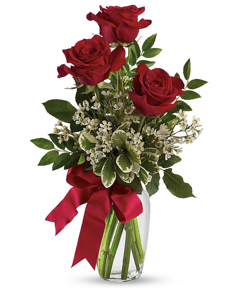 Thoughts of You Bouquet with Red Roses - It's the thought that counts, but it counts a bit more when it is expressed with three gorgeous red roses in a lovely arrangement tied up with a red satin ribbon. The flowers are bright and the price is right - the perfect combination for a sweet surprise. This charming bouquet includes three red roses accented with white waxflower, huckleberry and pittosporum along with a red satin ribbon. Delivered in a clear glass vase.
