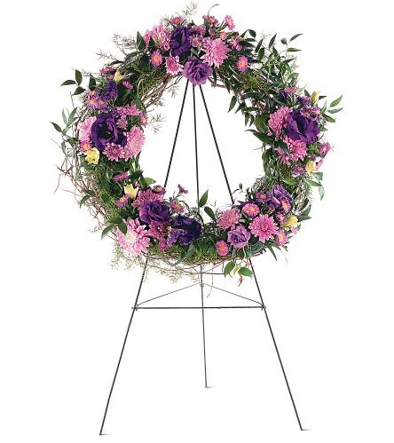 TF200-3 Grapevine Wreath -  This beautiful wreath with its purple and lavender chrysanthemums, lisianthus and asters offers friends and loved ones all the hope you wish them. One wreath is covered with fresh greens and clusters of purple, lavender and pink flowers and arrives on an easel. Approximately 26&quot; D 