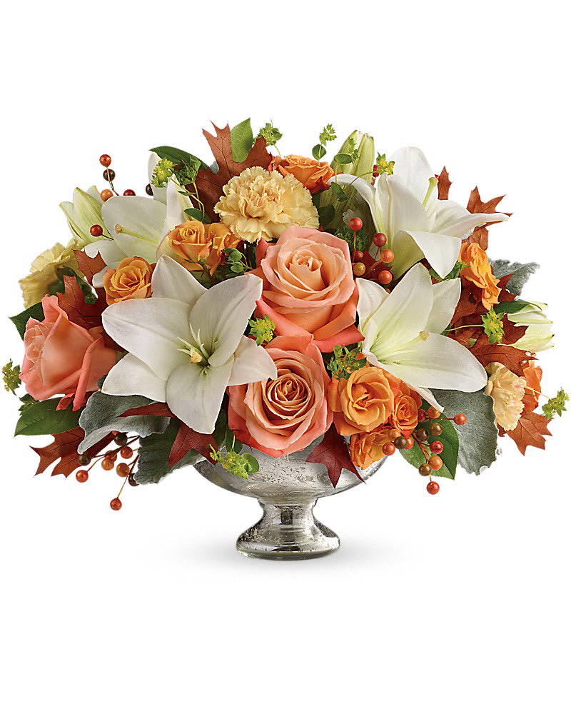Teleflora's Harvest Shimmer Centerpiece - Dress their fall table to impress by sending this shining bowl of the season's finest! Hand-delivered in a stunning mercury glass bowl, this artistic mix of white lilies and peach roses is sure to make their season a memorable one. This stunning centerpiece arrangement features peach and light orange roses, white asiatic lilies, peach carnations and orange berries and is finished with dusty miller, bupleurum and lemon leaf. Delivered in a Mercury Glass bowl.