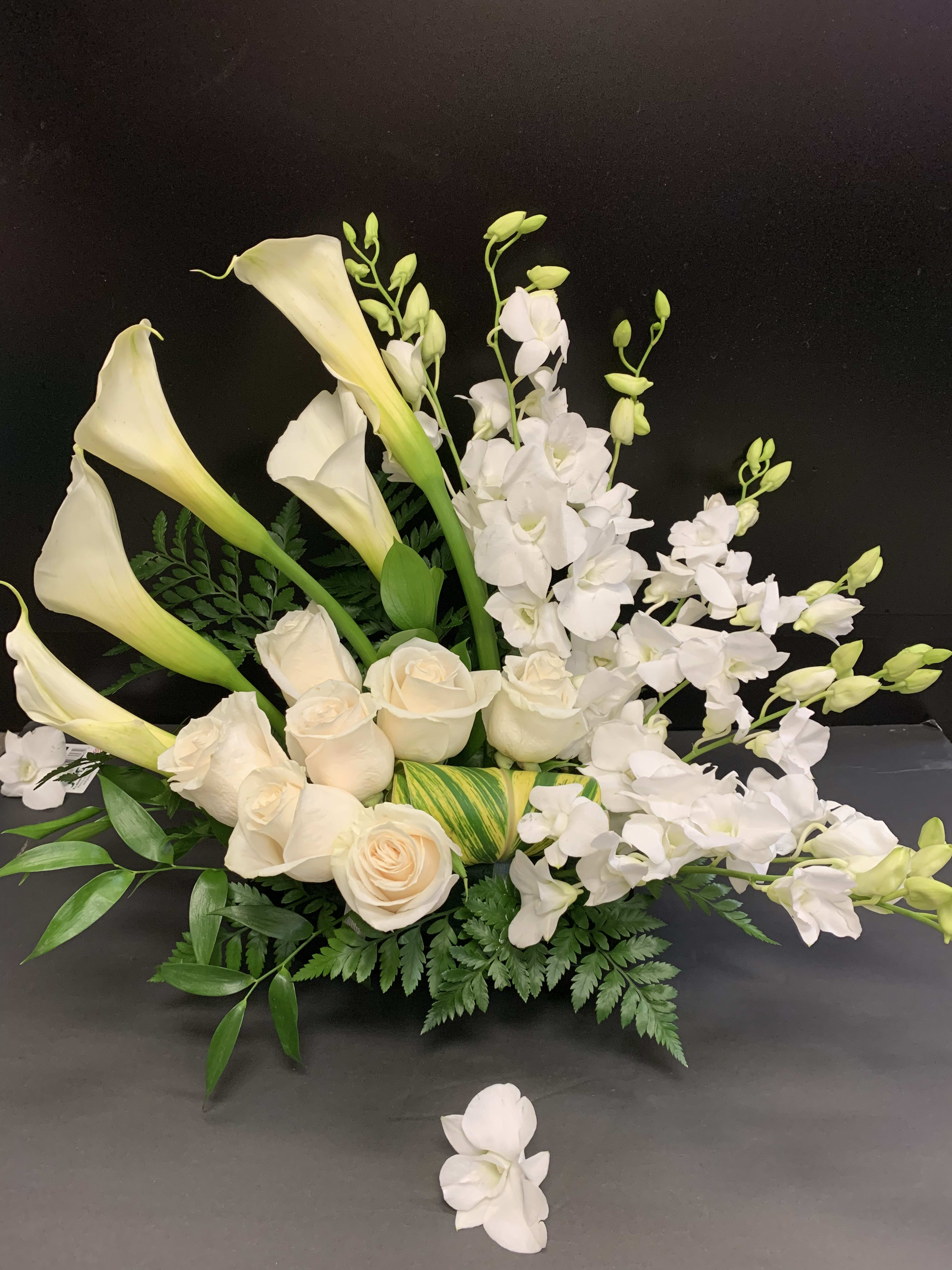 In loving memory In loving memory - 9 white dendrobium orchids 7 white 50 cm roses 5 white open cut calla lilies 10 variegated aspidistra leave 3 sword fern fronds 2 italian ruscus stems 1 floral foam block