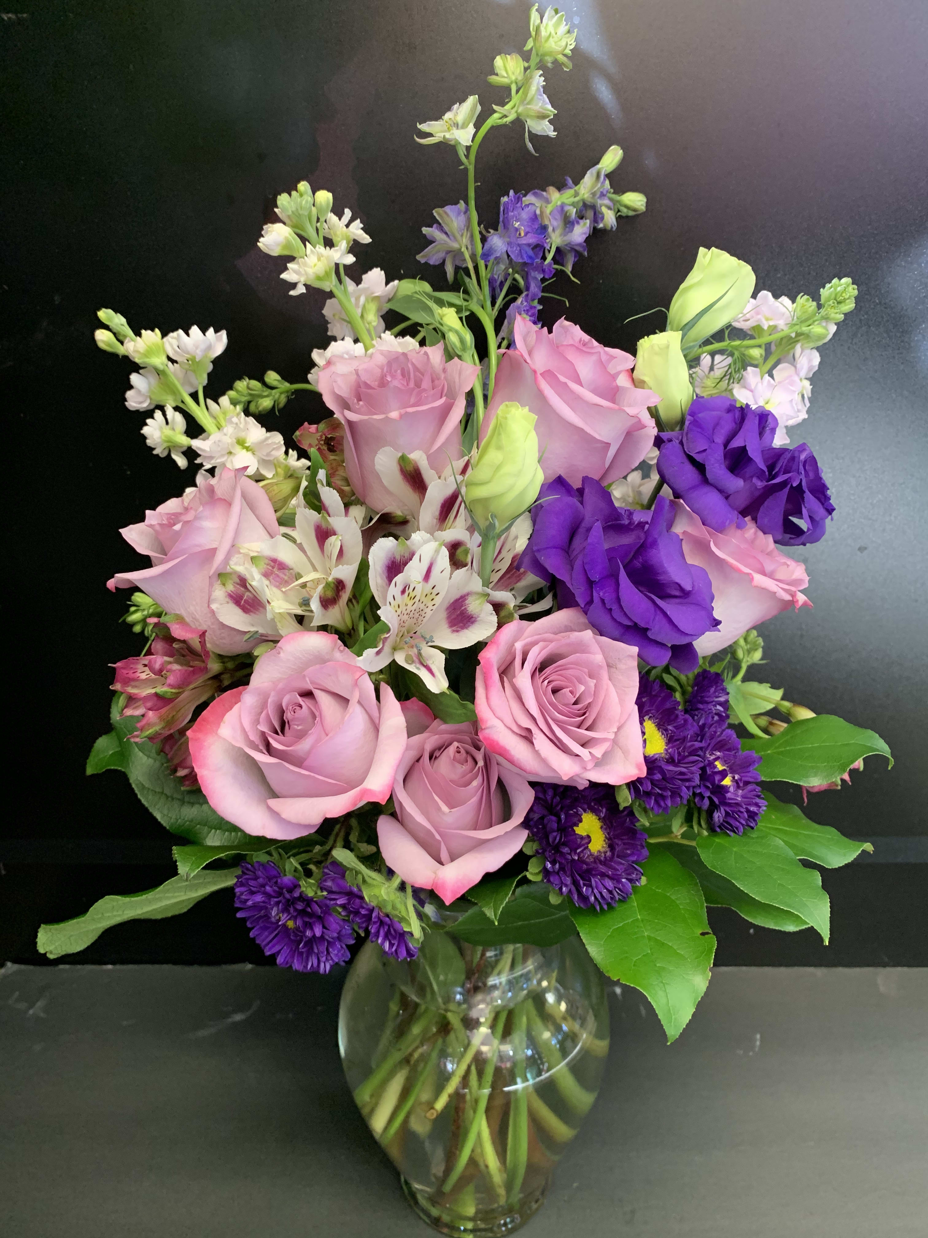 Enchanted Cottage - As enchanting as coming across a hidden cottage in the countryside! Lush white roses and purple stock mix with delicate lavender waxflower and green pitta negra for an elegant English garden look. 